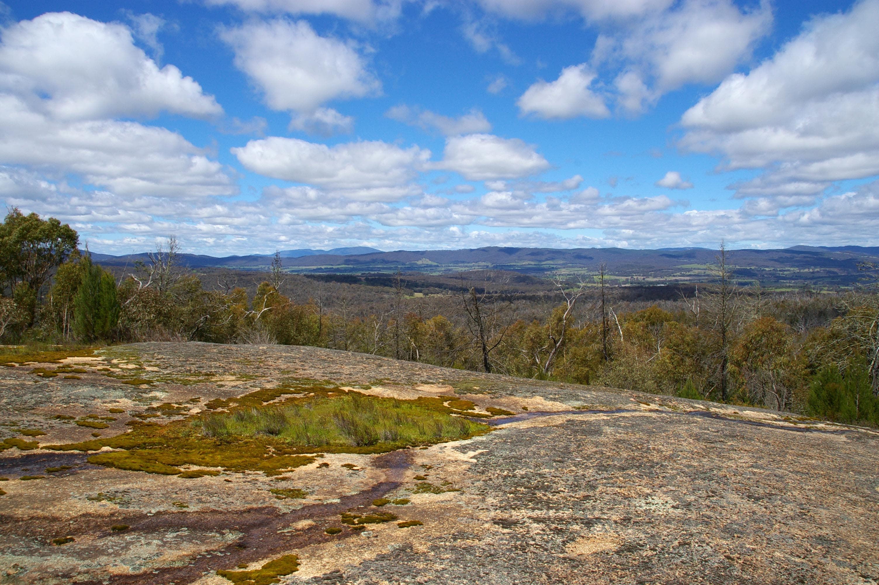 Panoramic view from Mount Pilot Summit looking south across the high country, layered ridges receding into haze under a clear sky.